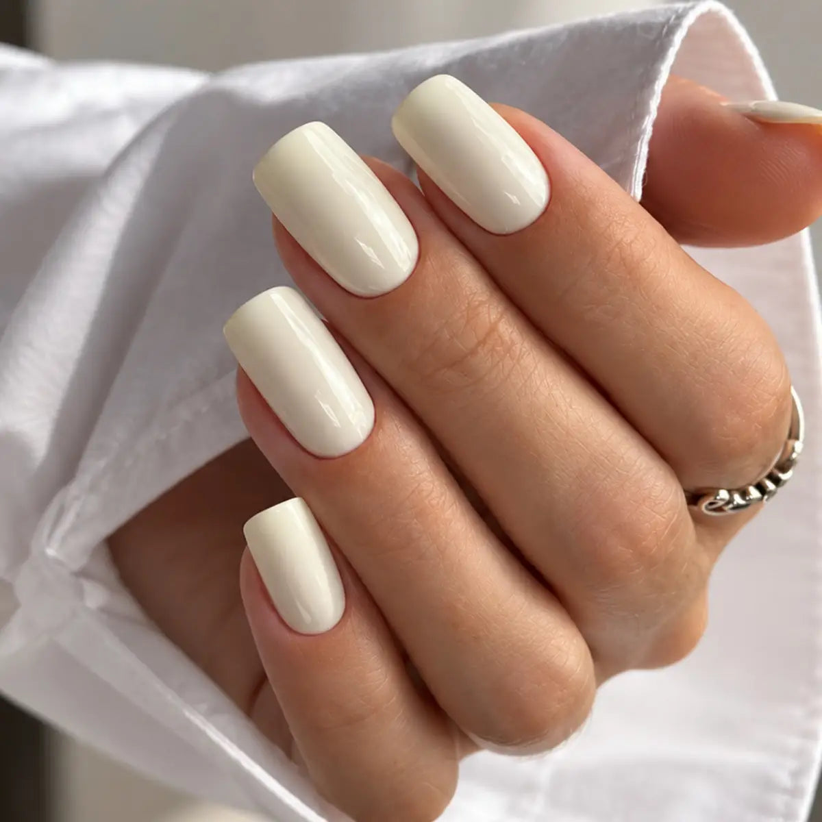 Manicure con semipermanente W018 Burro Cold Nails, unghie bianco burro su mano con anello